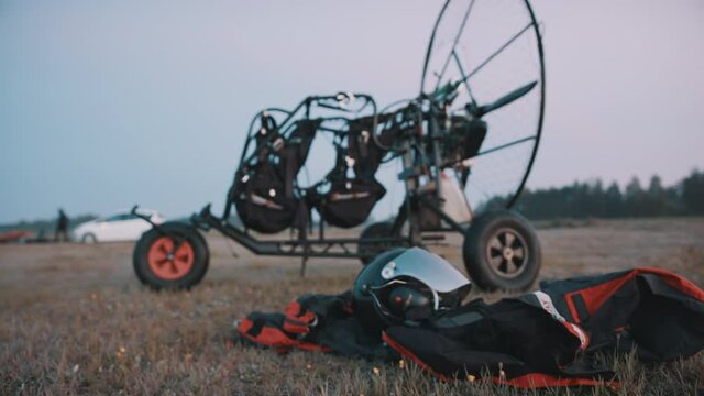 Equipment for gliding is on site, prepared for use. Tandem motor powered paragliding at twilight. 