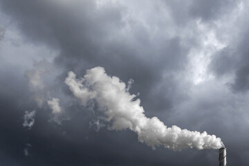 Obraz premium The chimney in deep blue heavy sky of a thermal power plant, the smoke extracted in the production process from pipe. Environment. Pollution..