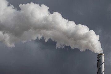 The chimney in deep blue heavy sky of a thermal power plant, the smoke extracted in the production...