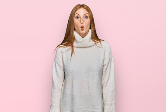 Young irish woman wearing casual winter sweater making fish face with lips, crazy and comical gesture. funny expression.