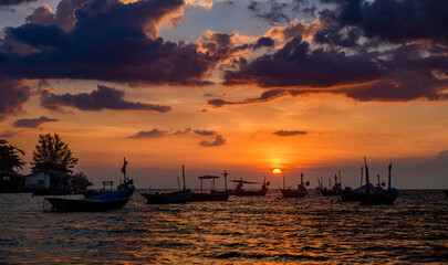 Fototapeta na wymiar Silhouette fishery boats in the sunset time.