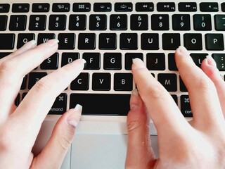 close-up of female hands working on computer keyboard