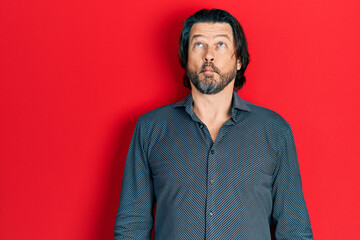 Middle age caucasian man wearing casual clothes making fish face with lips, crazy and comical gesture. funny expression.