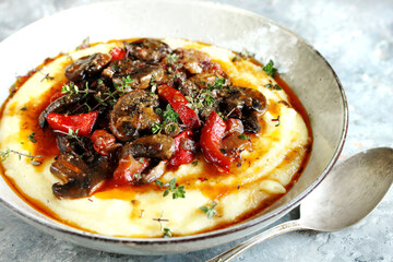 corn porridge (polenta) with fried mushrooms and bell peppers. Served with grated parmesan.