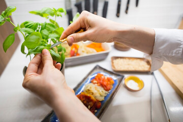 chef cutting basil and preparing a healthy meal