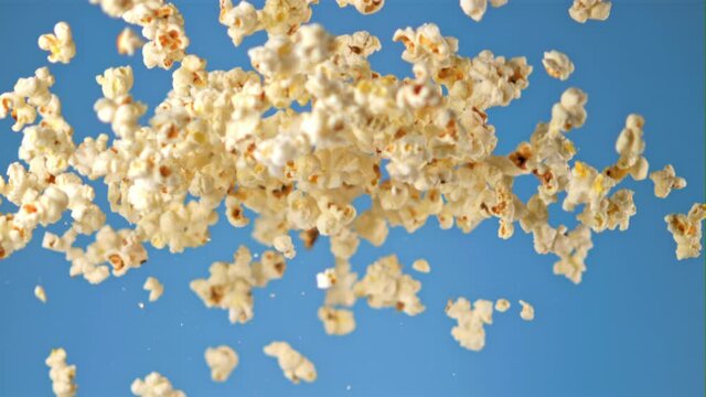 Super slow motion popcorn takes off on a blue background. Filmed on a high-speed camera at 1000 fps. High quality FullHD footage