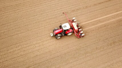 Traktor mit Sämaschine bei der Aussaat von Mais auf einem Acker, Landwirtschaft, Ernährung,...