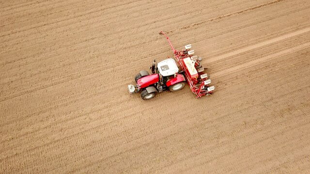 Traktor mit S&auml;maschine bei der Aussaat von Mais auf einem Acker, Landwirtschaft, Ern&auml;hrung, Pflanzenanbau, Vogelperspektive