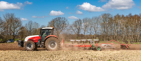  Tractor with plough and roundabout harrow cultivating the soil in the field | CP5171
