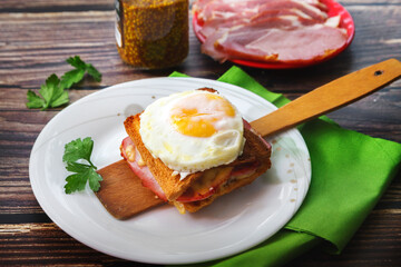 scrambled eggs with bread on a wooden spatula and a white plate