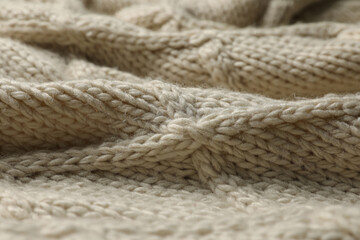 Beige knitted wool texture as background, closeup