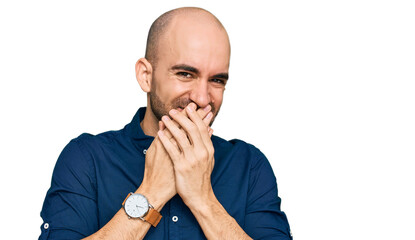 Young hispanic man wearing casual clothes laughing and embarrassed giggle covering mouth with...