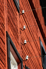 Old porcelain telegraph insulators in a row on an old traditional red and black Scandinavian cottage