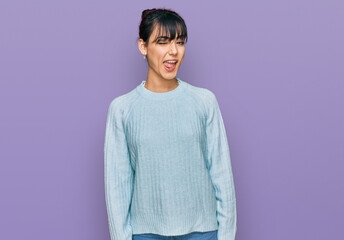 Young hispanic woman wearing casual clothes winking looking at the camera with sexy expression,...