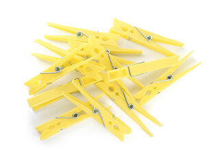 Yellow plastic clothespins on white background, top view