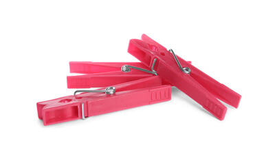 Bright pink plastic clothespins on white background