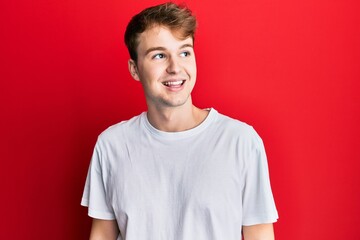 Young caucasian man wearing casual white t shirt looking to side, relax profile pose with natural face and confident smile.