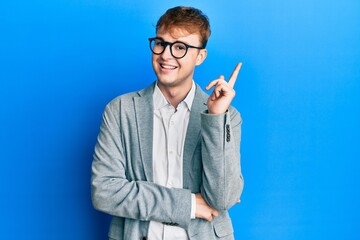 Young caucasian man wearing elegant clothes and glasses with a big smile on face, pointing with...