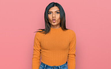 Obraz premium Young latin transsexual transgender woman wearing casual clothes making fish face with lips, crazy and comical gesture. funny expression.