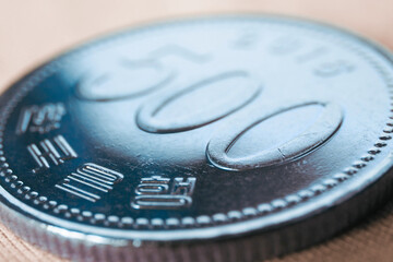 Translation: Bank of Korea. 500 won coin close-up. Tinted illustration about money, banking, finance and economy of South Korea. Macro