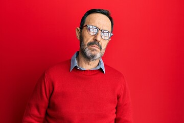 Fototapeta premium Middle age hispanic man wearing casual clothes and glasses relaxed with serious expression on face. simple and natural looking at the camera.