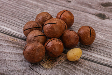 Brown macadamia nut heap over background
