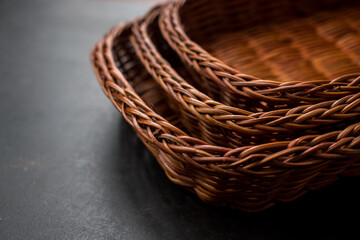 Obraz premium Some brown handmade baskets on a black wooden table 
