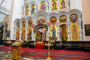 Interior of a Christian church. Gold, red and white colors .Icons of saints, altar, candles.