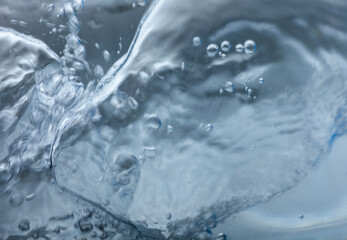 Blue gray splashing cosmetic moisturizer, micellar water,  toner, or emulsion abstract background. Transpatent texture with bubbles