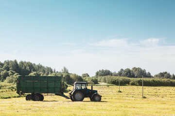 Tractor with a trailer in the field for agricultural work.