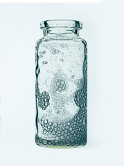 Cosmetic serum bottle sample on cold green blue background