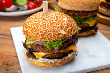 Tasty vegetarian cheeseburgers and hamburgers with round patties or burgers made from grains, vegetables and legumes