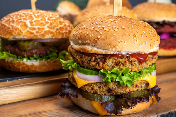 Tasty vegetarian cheeseburgers and hamburgers with round patties or burgers made from grains, vegetables and legumes