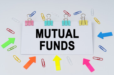 On the table there are paper clips and directional arrows, a sign that says - MUTUAL FUNDS