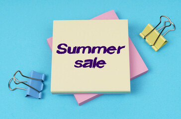 On the table are paper clips, note paper with text - Summer sale