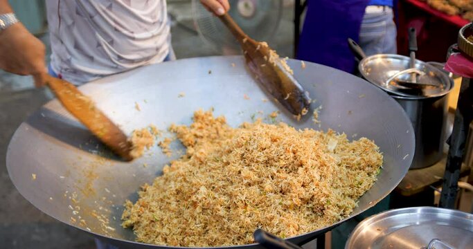 Thai street vendor cooking Mee-Krob, crispy noodles , sweet and sour crispy 
