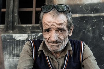Fototapeta premium Portrait of a Georgian man. The worker takes a break and rests in the air. The expressive eyes of a wise man, the tired look of an elderly man. Day. Fall. Georgia.