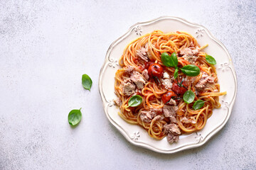 Spaghetti pasta with tuna in tomato sauce. Top view with copy space.