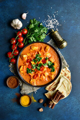 Chicken tikka masala - traditional dish of indian cuisine in a black bowl.Top view with copy space.