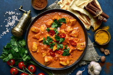 Chicken tikka masala - traditional dish of indian cuisine in a black bowl.Top view with copy space.