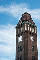 stary budynek z cegły - wieża z zegarem na tle nieba