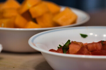 freshly chopped tomato and canteloupe chunks in bowls