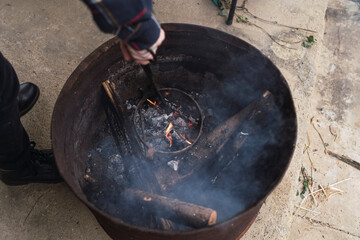 Closeup shot of a person fixing coal on a grill