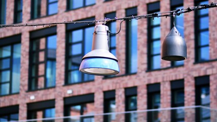 Obraz premium Street lamp hanging on long wire against modern building background