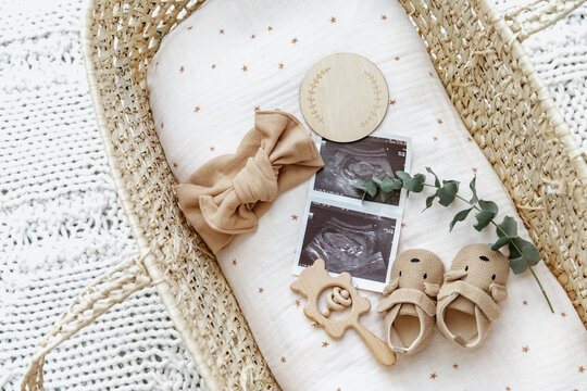 Flat lay composition with cute baby items in basket. The concept of awaiting baby, pregnancy