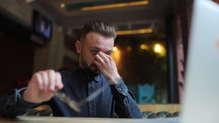 man got sick eyes from glasses, working with a computer. Eye disease concept and glasses selection.