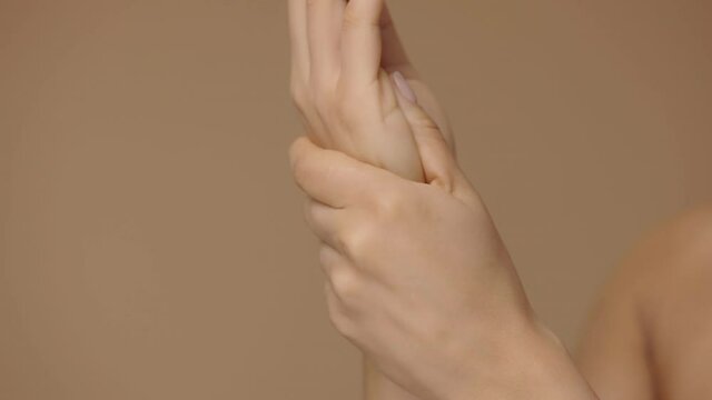 African American woman applying skincare cream on hands. Close up macro portrait of hands of mixed race female, rubbing cream with fingers. Slow motion ready, 4K at 59.94fps.