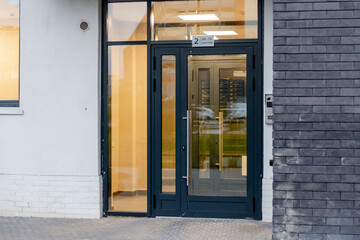 Entrance to a new apartment building. Glass door to the entrance. Entrance to the house without stairs. Mailboxes are visible through the glass.
