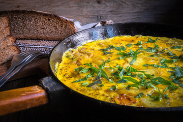 Rustic omelet with potatoes in a cast-iron pan cooked in the oven.