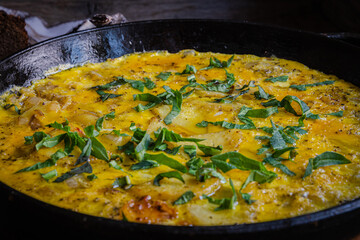 Rustic omelet with potatoes in a cast-iron pan cooked in the oven.